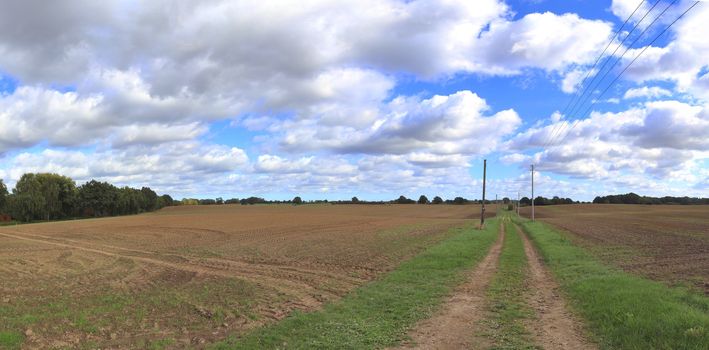 Beautiful high resolution panorama of a northern european country landscape with fields and green grass.