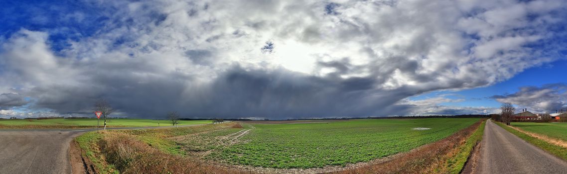 Beautiful high resolution panorama of a northern european country landscape with fields and green grass.