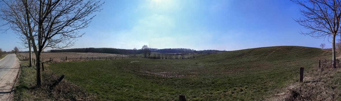 Beautiful high resolution panorama of a northern european country landscape with fields and green grass.