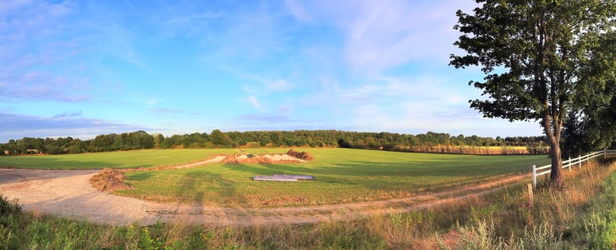 Beautiful high resolution panorama of a northern european country landscape with fields and green grass.