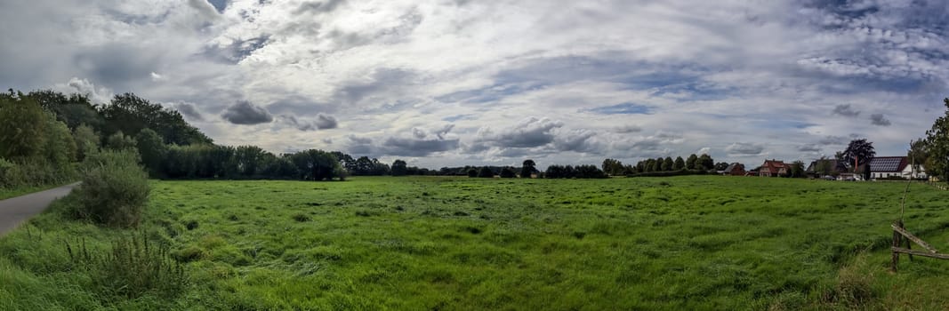 Beautiful high resolution panorama of a northern european country landscape with fields and green grass.