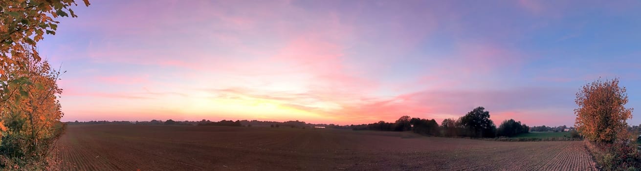 Beautiful high resolution panorama of a northern european country landscape with fields and green grass.