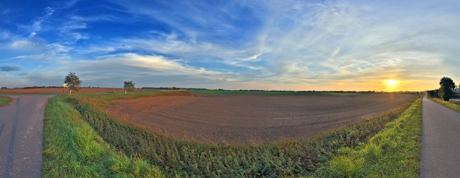 Beautiful high resolution panorama of a northern european country landscape with fields and green grass.