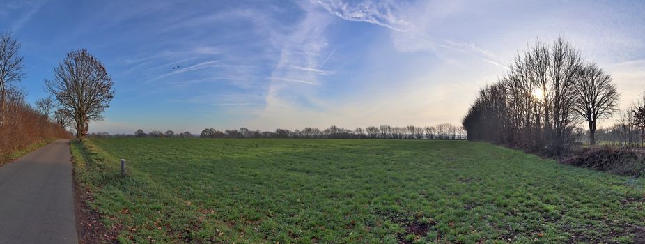 Beautiful high resolution panorama of a northern european country landscape with fields and green grass.