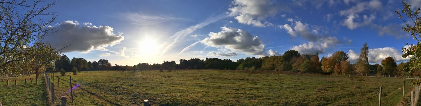 Beautiful high resolution panorama of a northern european country landscape with fields and green grass.