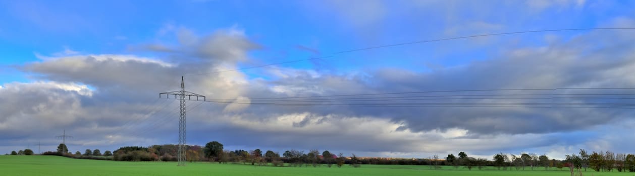 Beautiful high resolution panorama of a northern european country landscape with fields and green grass.