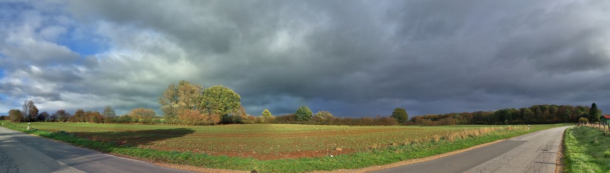 Beautiful high resolution panorama of a northern european country landscape with fields and green grass.