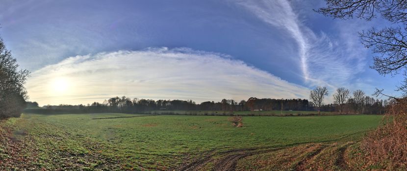 Beautiful high resolution panorama of a northern european country landscape with fields and green grass.