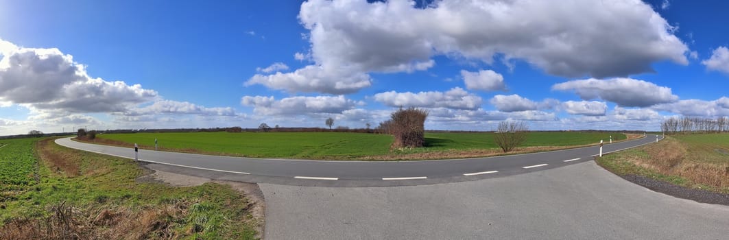 Beautiful high resolution panorama of a northern european country landscape with fields and green grass.