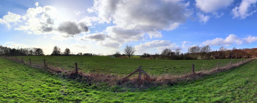 Beautiful high resolution panorama of a northern european country landscape with fields and green grass.