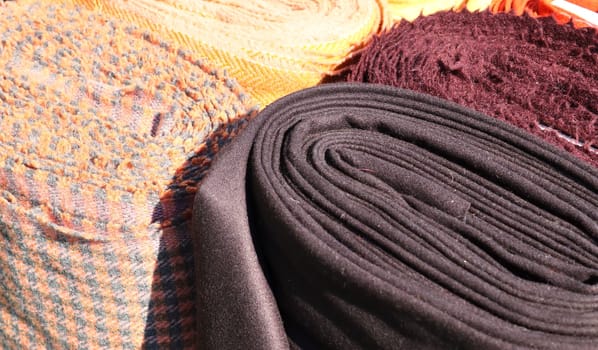 Detailed close up view on samples of cloth and fabrics in different colors found at a fabrics market.