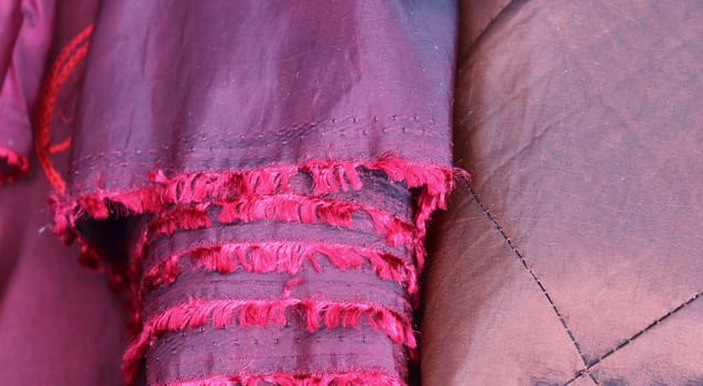 Detailed close up view on samples of cloth and fabrics in different colors found at a fabrics market.