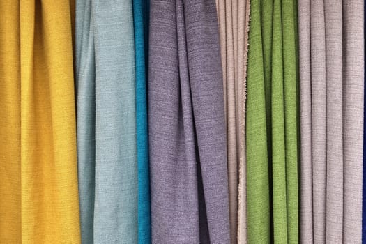 Detailed close up view on samples of cloth and fabrics in different colors found at a fabrics market.