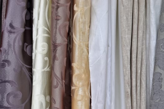 Detailed close up view on samples of cloth and fabrics in different colors found at a fabrics market.