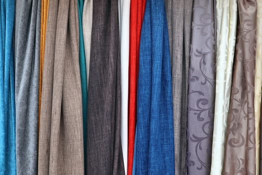 Detailed close up view on samples of cloth and fabrics in different colors found at a fabrics market.