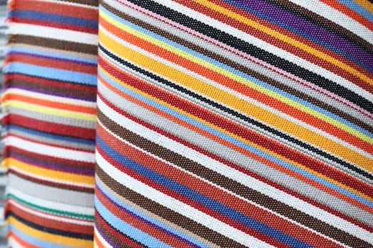 Detailed close up view on samples of cloth and fabrics in different colors found at a fabrics market.