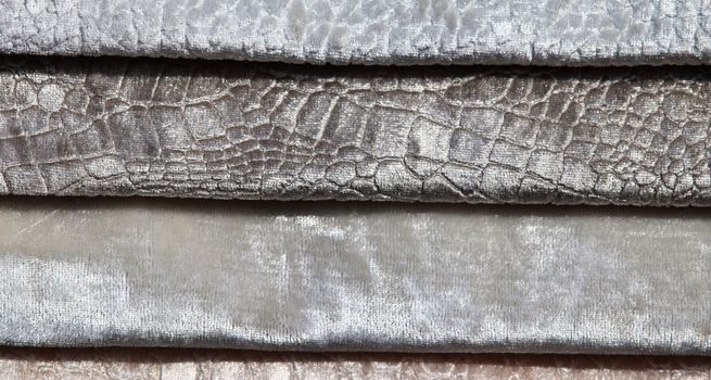 Detailed close up view on samples of cloth and fabrics in different colors found at a fabrics market.