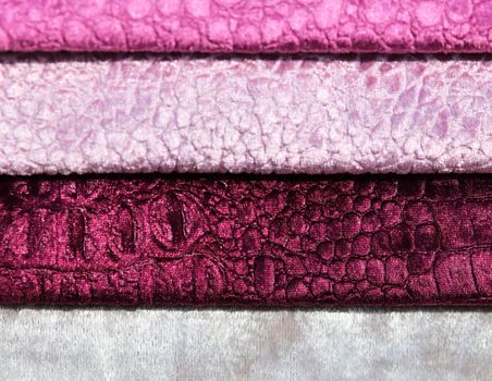 Detailed close up view on samples of cloth and fabrics in different colors found at a fabrics market.