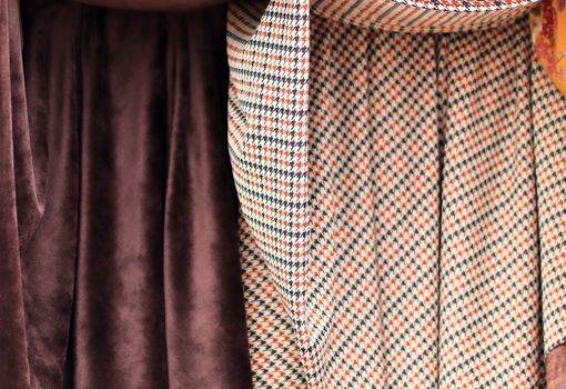 Detailed close up view on samples of cloth and fabrics in different colors found at a fabrics market.