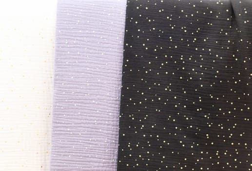 Detailed close up view on samples of cloth and fabrics in different colors found at a fabrics market.