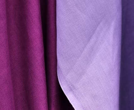 Detailed close up view on samples of cloth and fabrics in different colors found at a fabrics market.