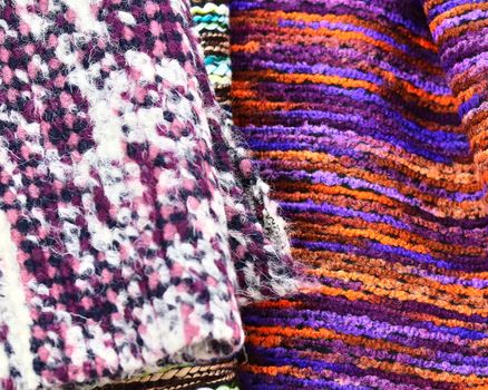 Detailed close up view on samples of cloth and fabrics in different colors found at a fabrics market.