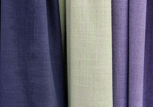 Detailed close up view on samples of cloth and fabrics in different colors found at a fabrics market.