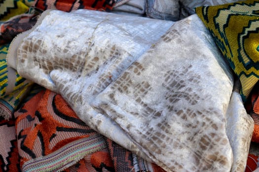 Detailed close up view on samples of cloth and fabrics in different colors found at a fabrics market.