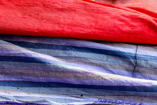 Detailed close up view on samples of cloth and fabrics in different colors found at a fabrics market.