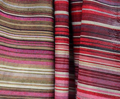 Detailed close up view on samples of cloth and fabrics in different colors found at a fabrics market.