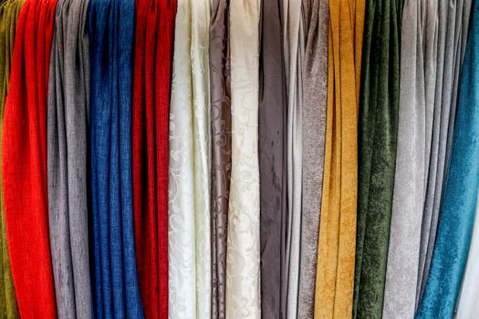 Detailed close up view on samples of cloth and fabrics in different colors found at a fabrics market.