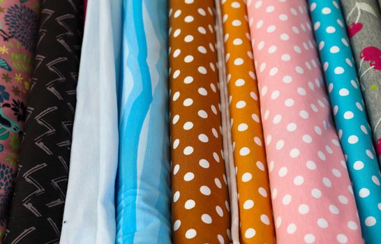 Detailed close up view on samples of cloth and fabrics in different colors found at a fabrics market.