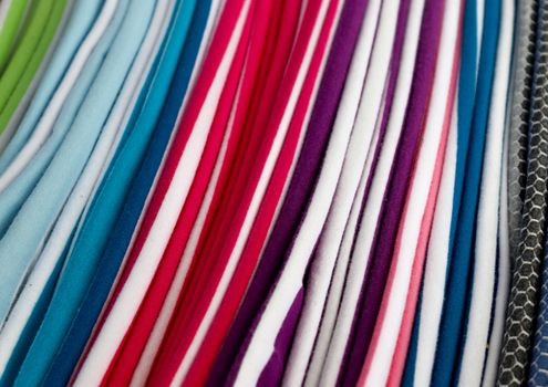 Detailed close up view on samples of cloth and fabrics in different colors found at a fabrics market.