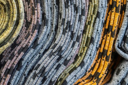 Detailed close up view on samples of cloth and fabrics in different colors found at a fabrics market.