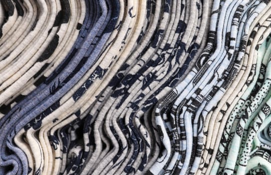 Detailed close up view on samples of cloth and fabrics in different colors found at a fabrics market.