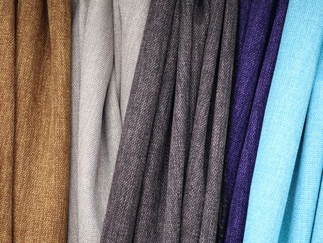 Detailed close up view on samples of cloth and fabrics in different colors found at a fabrics market.