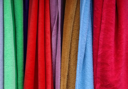 Detailed close up view on samples of cloth and fabrics in different colors found at a fabrics market.