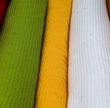 Detailed close up view on samples of cloth and fabrics in different colors found at a fabrics market.