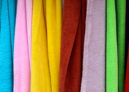 Detailed close up view on samples of cloth and fabrics in different colors found at a fabrics market.