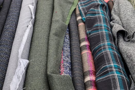 Detailed close up view on samples of cloth and fabrics in different colors found at a fabrics market.