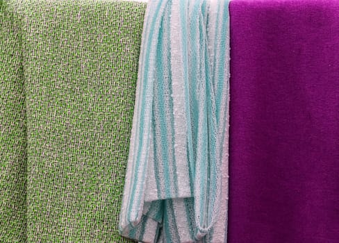 Detailed close up view on samples of cloth and fabrics in different colors found at a fabrics market.