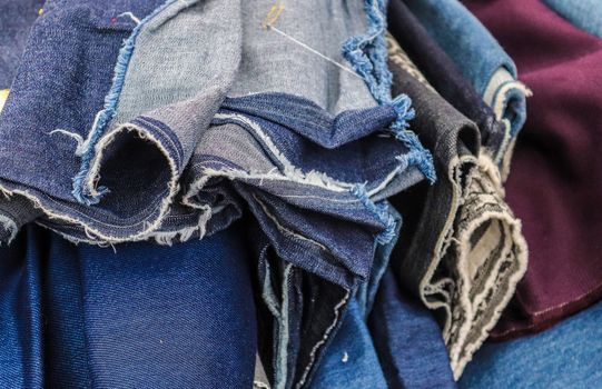 Detailed close up view on samples of cloth and fabrics in different colors found at a fabrics market.