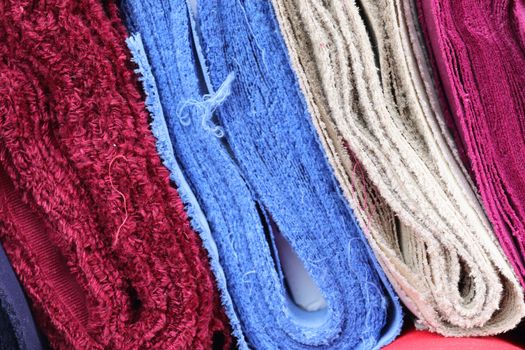 Detailed close up view on samples of cloth and fabrics in different colors found at a fabrics market.