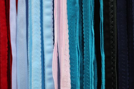 Detailed close up view on samples of cloth and fabrics in different colors found at a fabrics market.