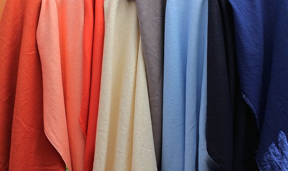 Detailed close up view on samples of cloth and fabrics in different colors found at a fabrics market.