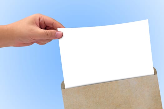 Hand holding white paper and brown envelope on blue background
