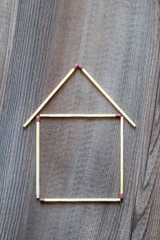 An image of a simple house of match sticks