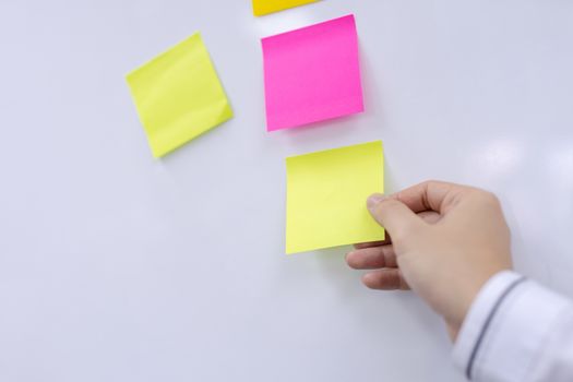 Post-it note with hand on white background