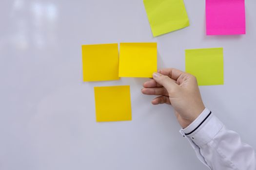 Post-it note with hand on white background