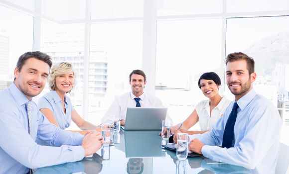 Smartly dressed young executives sitting around conference table in office